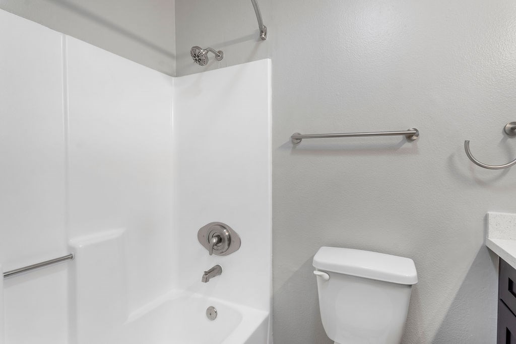 A white toilet is next to a white bathtub in a bathroom.