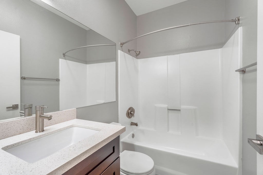 A white bathroom with a toilet, sink, and bathtub.