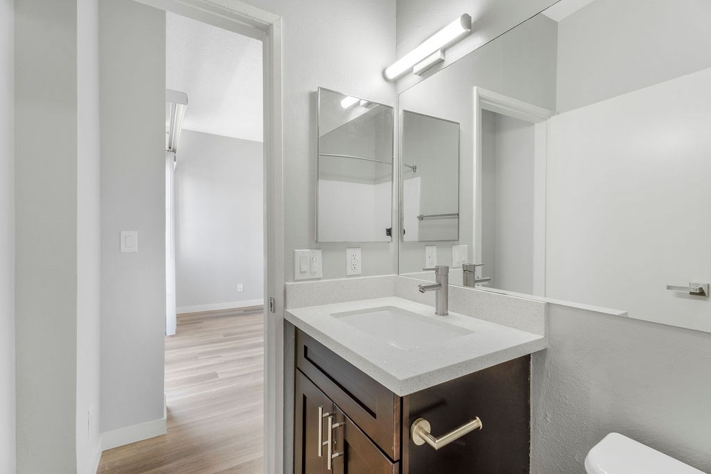 A bathroom with a white sink and a mirror above it.