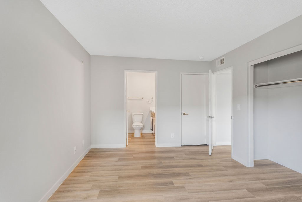 A room with a toilet in the middle and a sliding door on the right.
