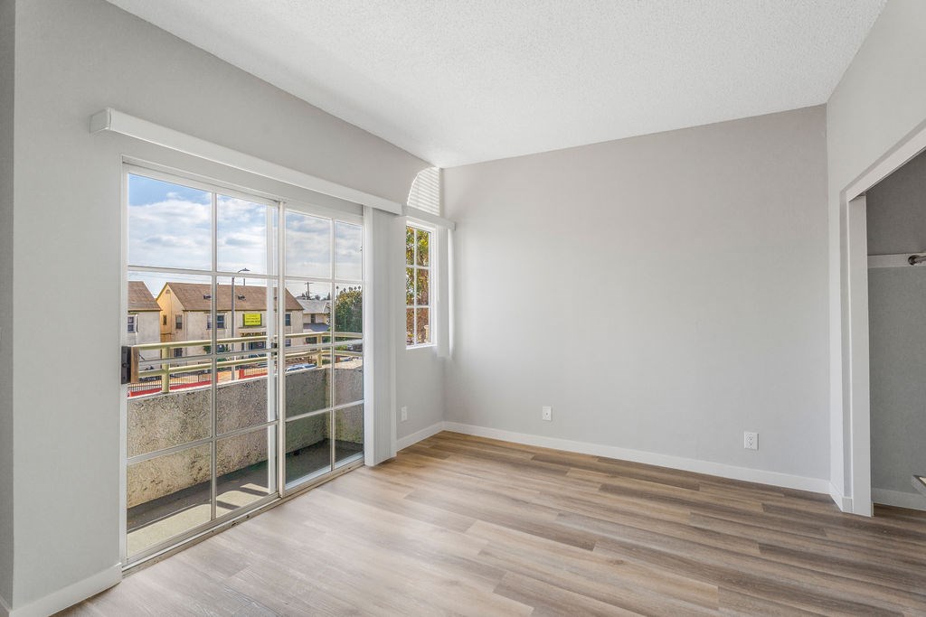 A room with a sliding glass door leading to a balcony.