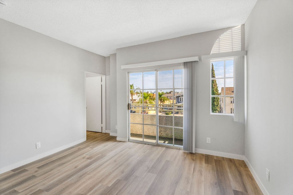 A room with a sliding glass door leading to a balcony.