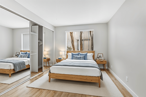 A bedroom with a large bed and a mirror on the wall.