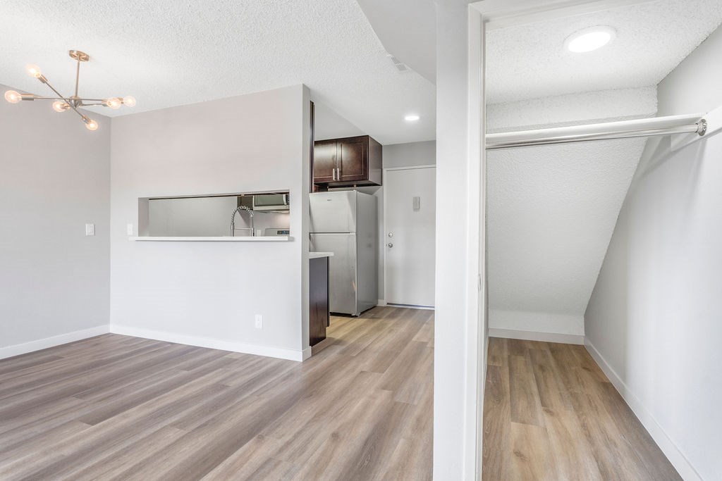 A kitchen with a refrigerator, microwave, and oven.