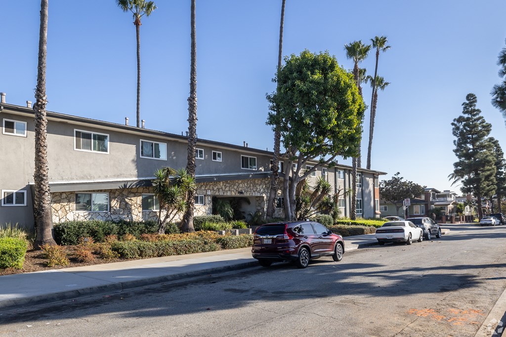 A red car is parked on the side of a street.