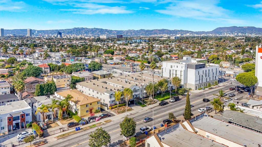 A cityscape with buildings, roads, and cars under a clear sky.