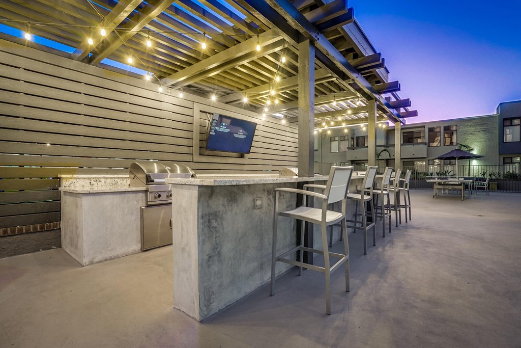 a patio with a bar and tables with chairs