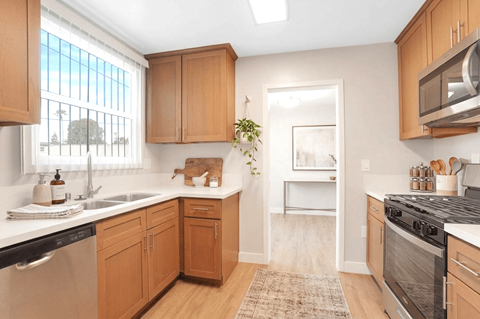 A kitchen with wooden cabinets and a black stove top oven.