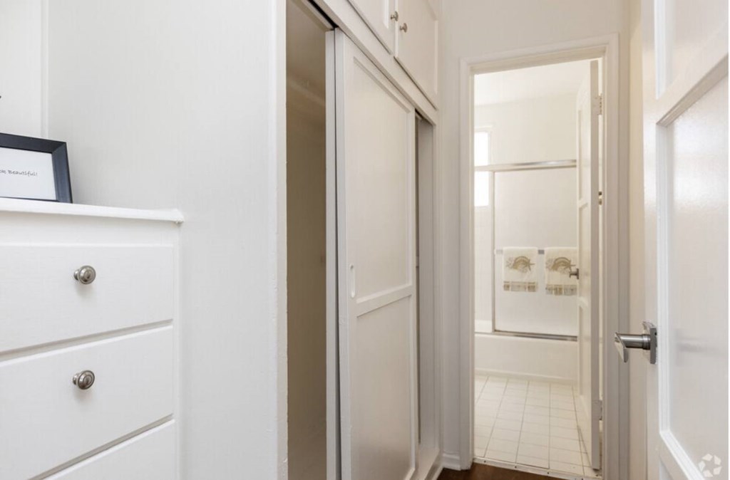 A white drawer with a silver handle sits next to a white door.