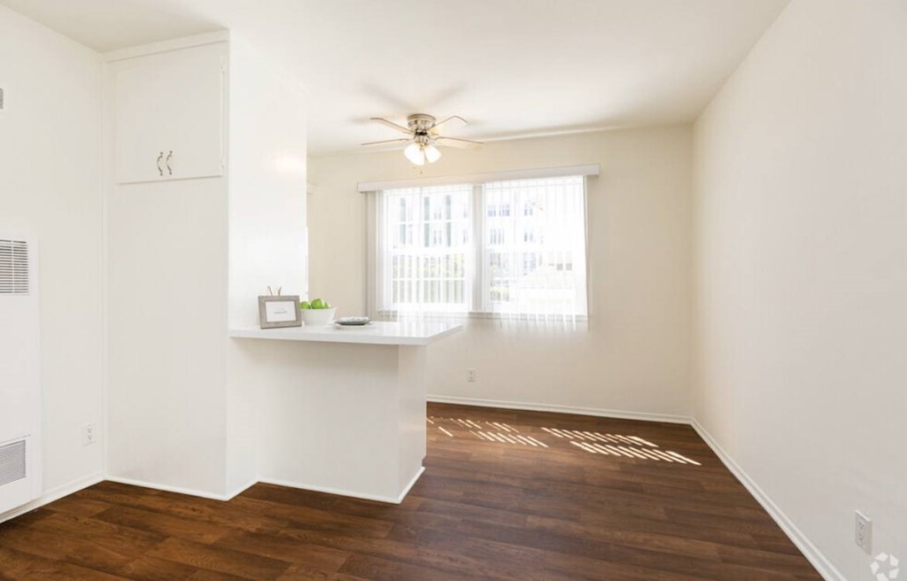 A room with a window and a ceiling fan.