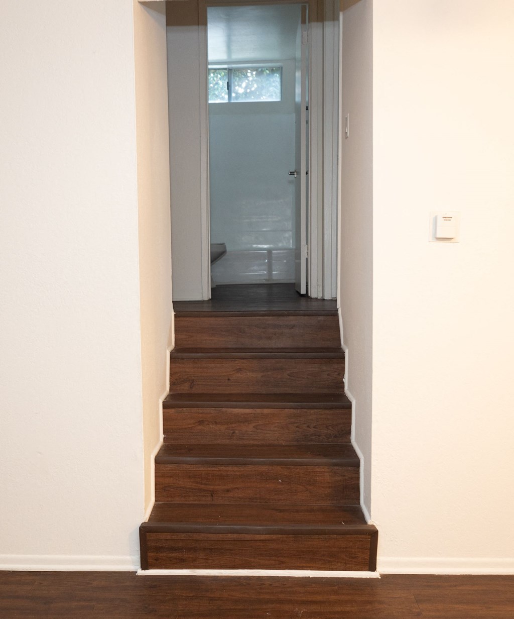 a staircase in a home with wood floors and white walls