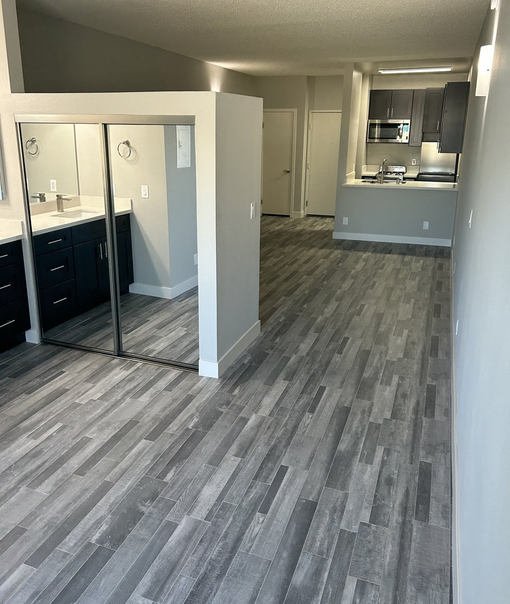 an empty kitchen and living room with wood flooring