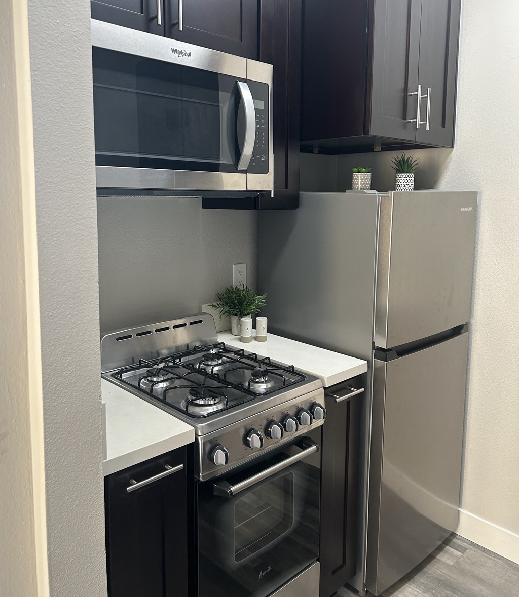 a kitchen with a stove and a microwave and a refrigerator