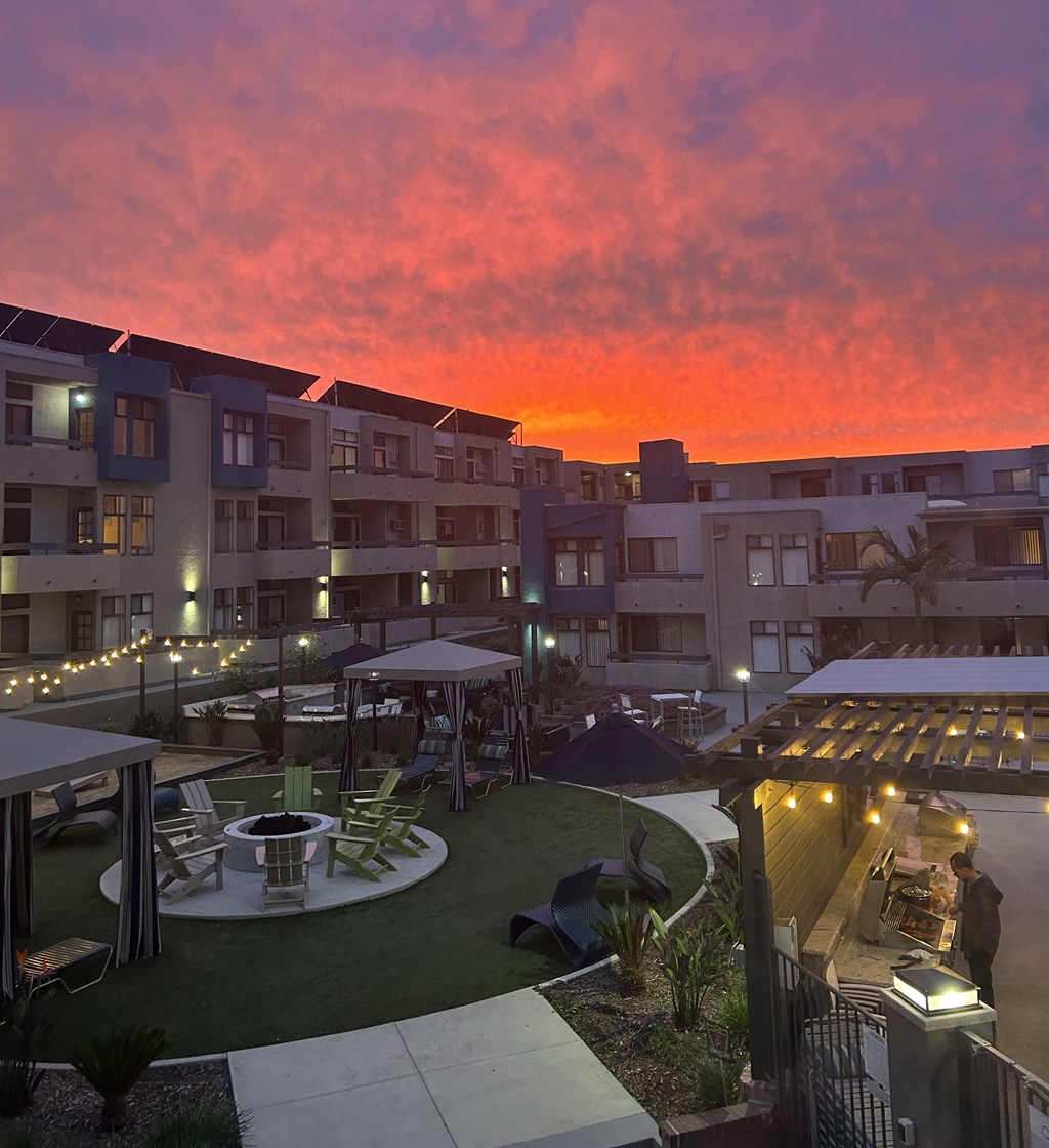 a view of the sunset over an apartment complex with a courtyard