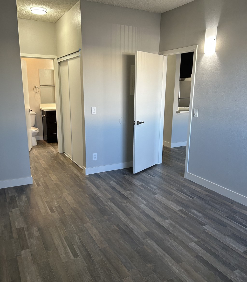a renovated living room with wood flooring and a bathroom