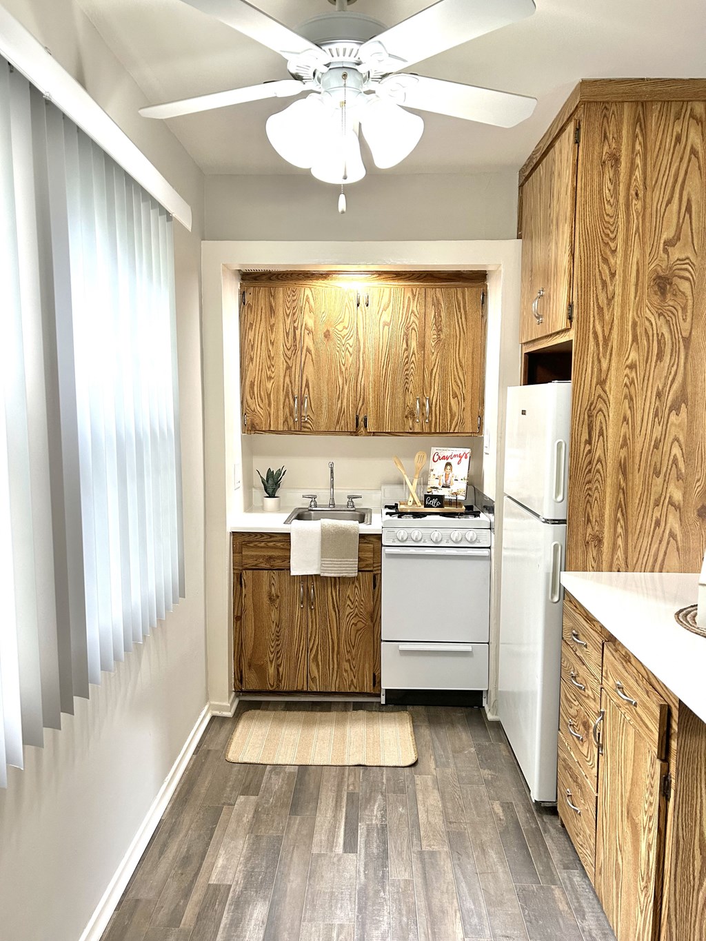 a small kitchen with white appliances and wooden cabinets