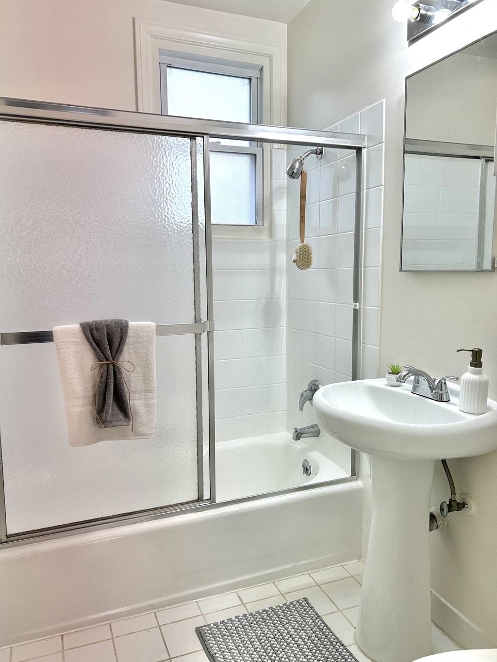 a white bathroom with a shower and a sink