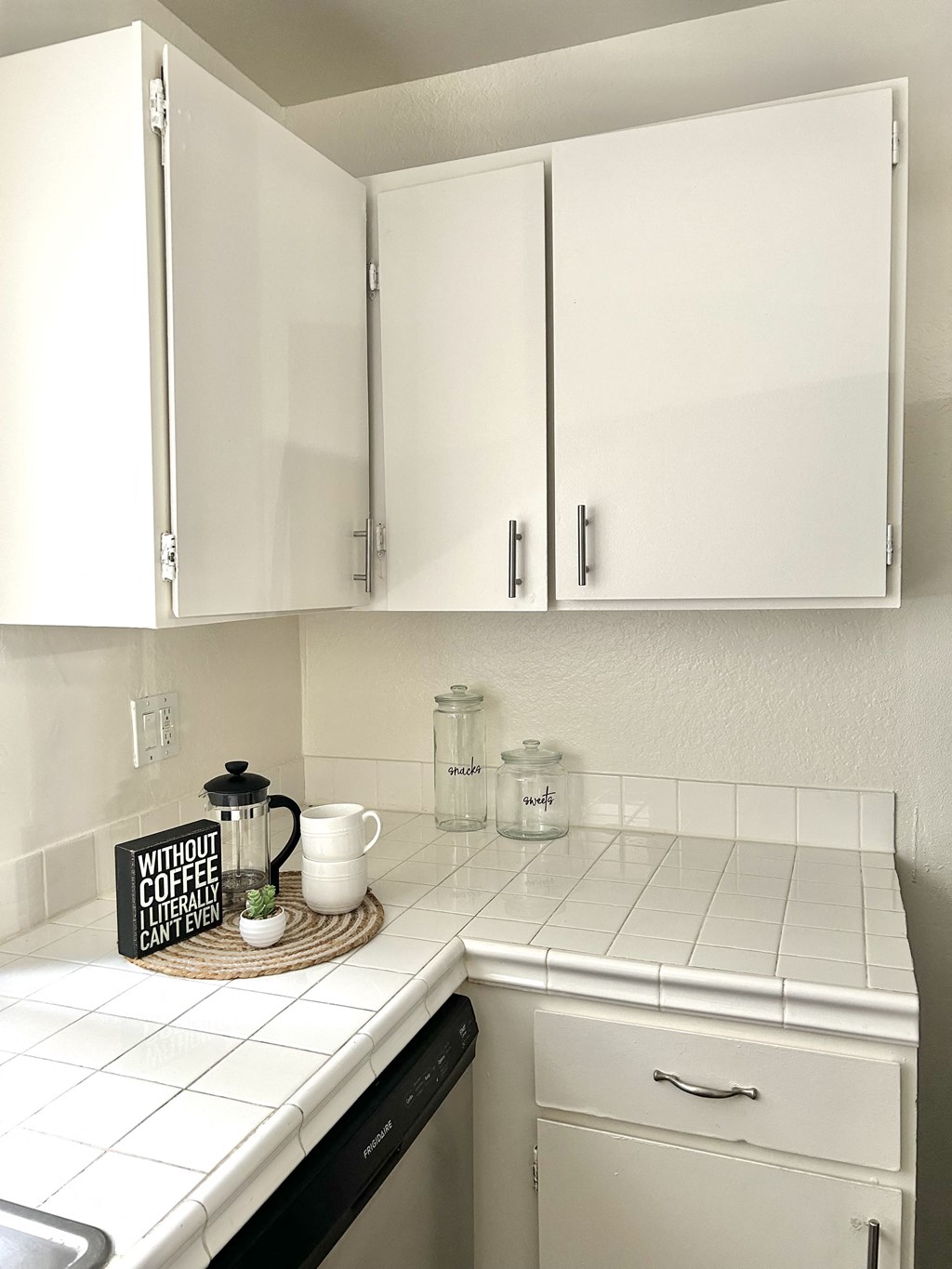 a small kitchen with white cabinets and a counter top and a sink