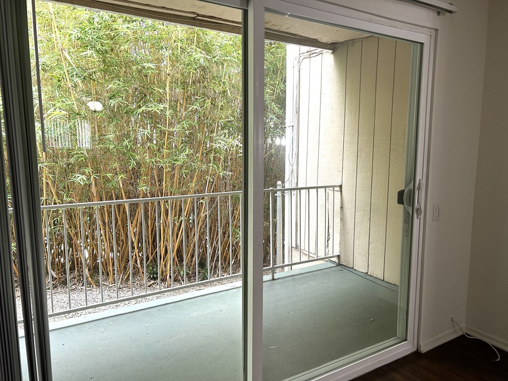 a room with a balcony and a sliding glass door