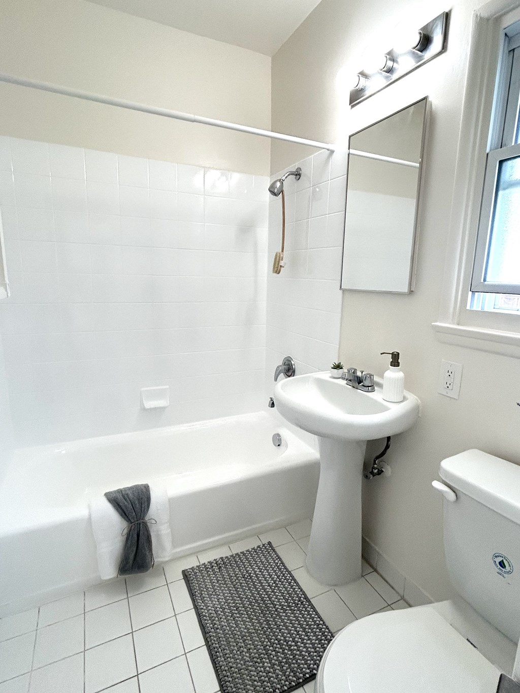 A white bathroom with a white toilet, sink, and tub.