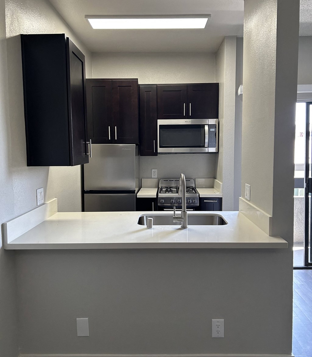 a kitchen with a sink and a stove and a microwave