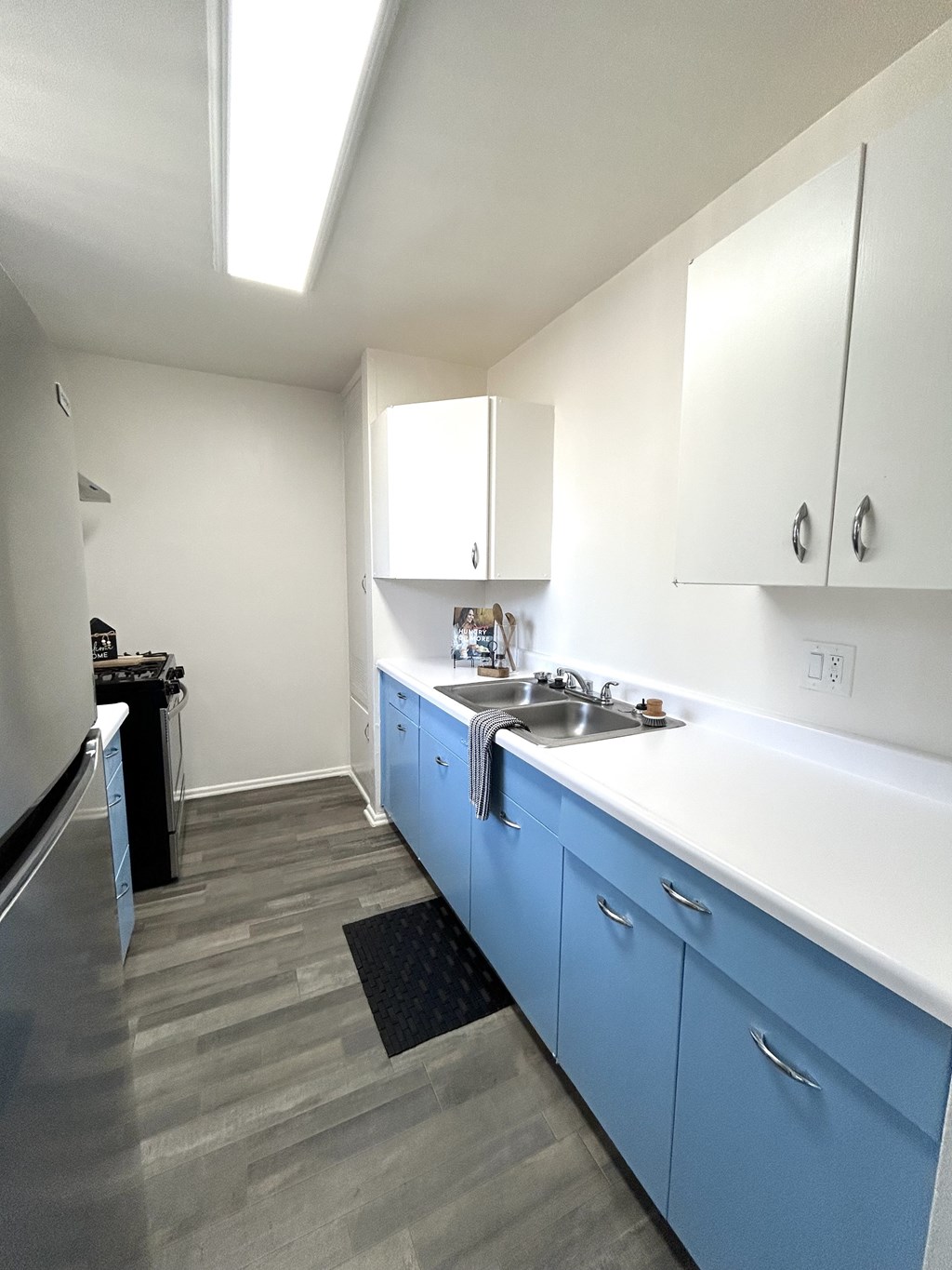 A kitchen with blue cabinets and a white counter.