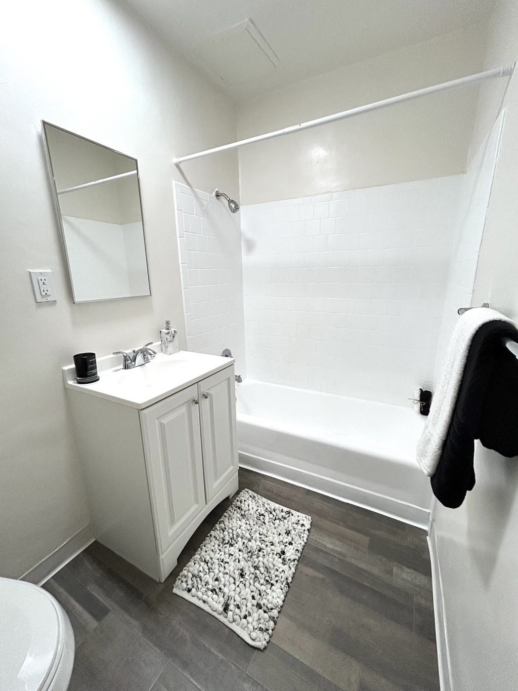 A white bathroom with a toilet, sink, and mirror.