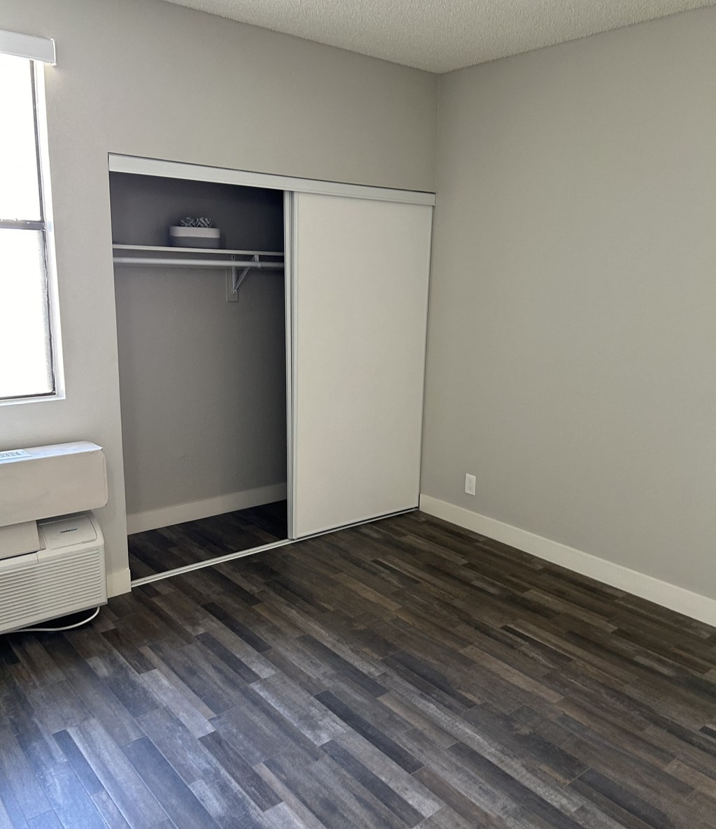 an empty room with a closet and wooden floors