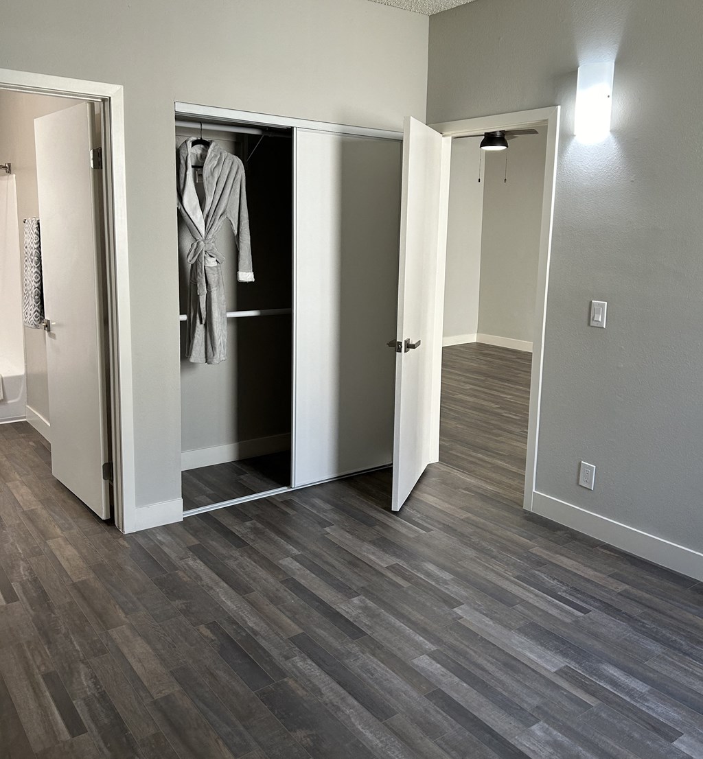 a renovated living room with a closet and wood flooring