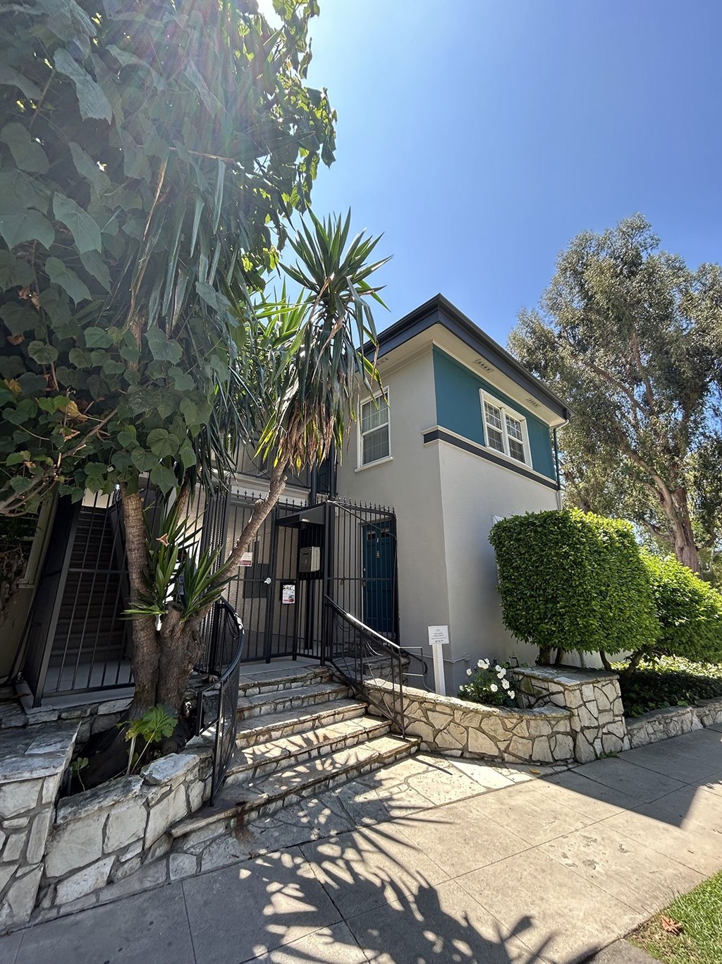 A house with a green roof and a stone wall.