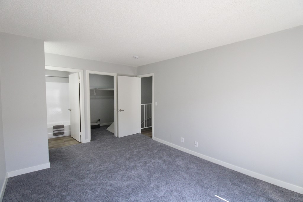 A room with a grey carpet and white walls.