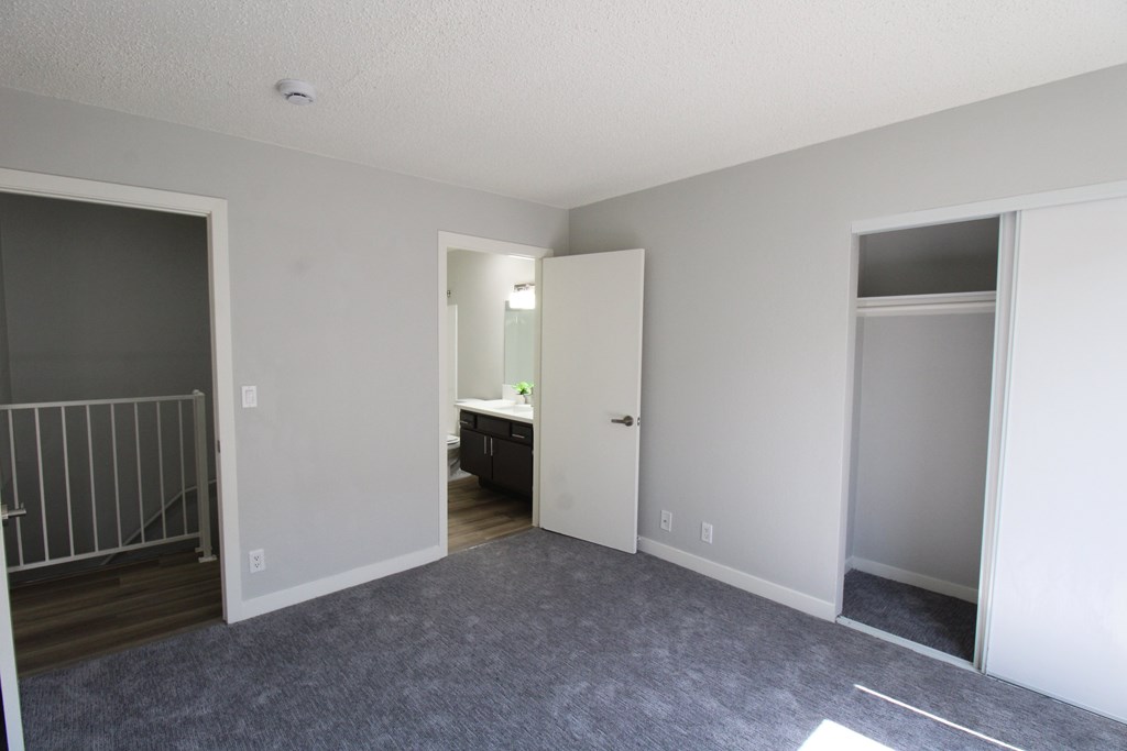 A spacious room with a grey carpet and white walls.