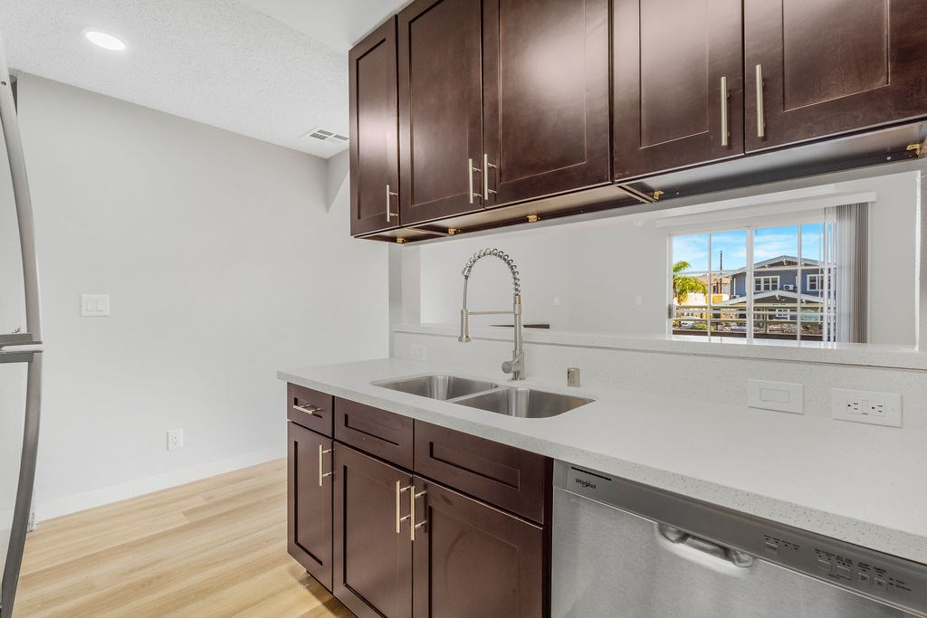 A kitchen with brown cabinets and a stainless steel dishwasher.