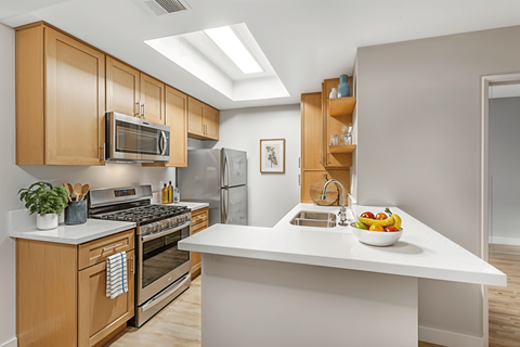 A modern kitchen with wooden cabinets and stainless steel appliances.