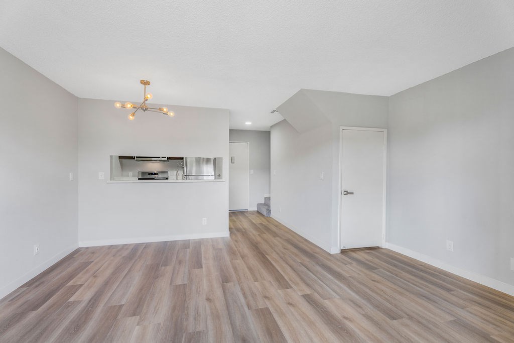 A room with wooden floors and a chandelier.
