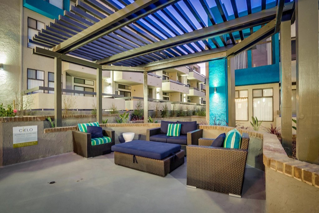 a patio with couches and a table in front of a building