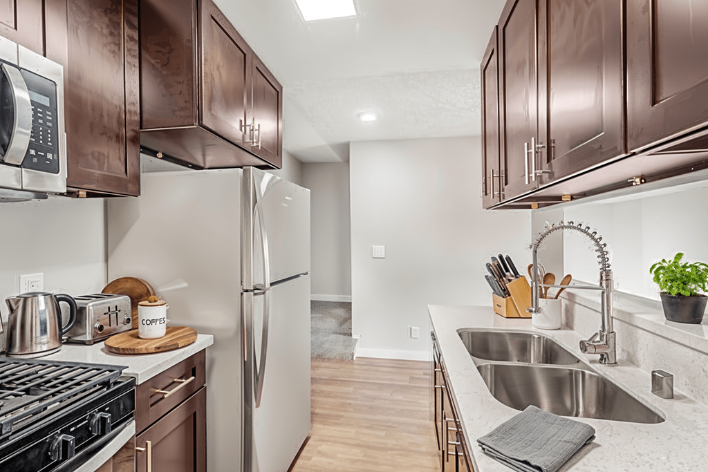 A kitchen with brown cabinets and a stove top oven.