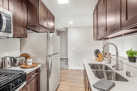 A kitchen with brown cabinets and a stove top oven.