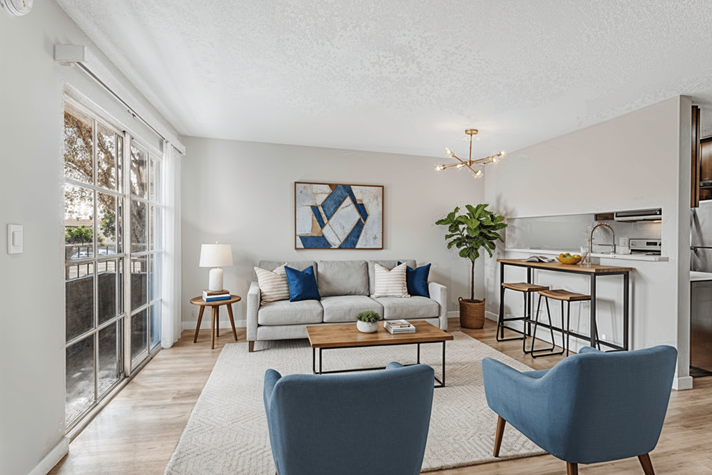 A living room with a couch, two chairs, and a dining table.