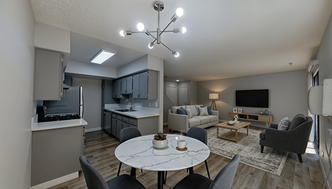 A modern living room with a dining table and grey chairs.