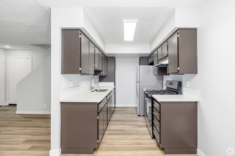 A modern kitchen with brown cabinets and a white countertop.