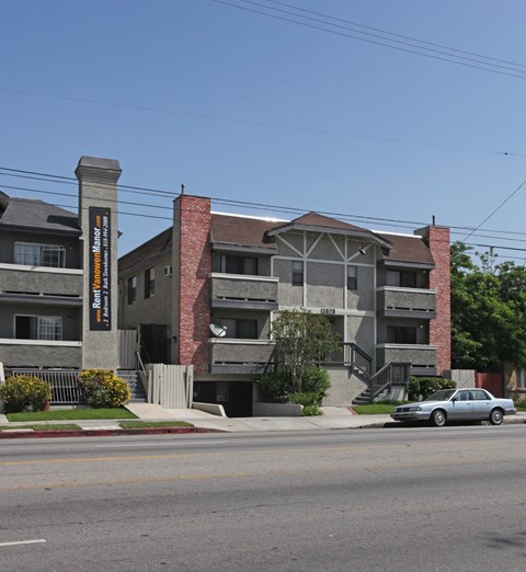 A car is parked on the street in front of a building.