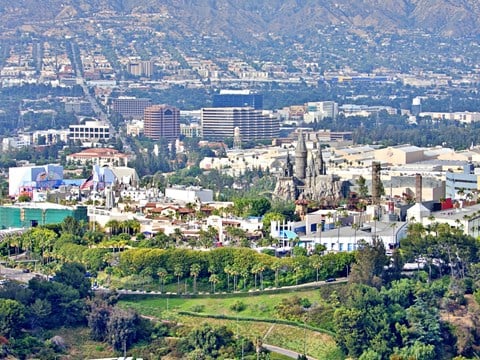 A cityscape with buildings and greenery in the foreground.