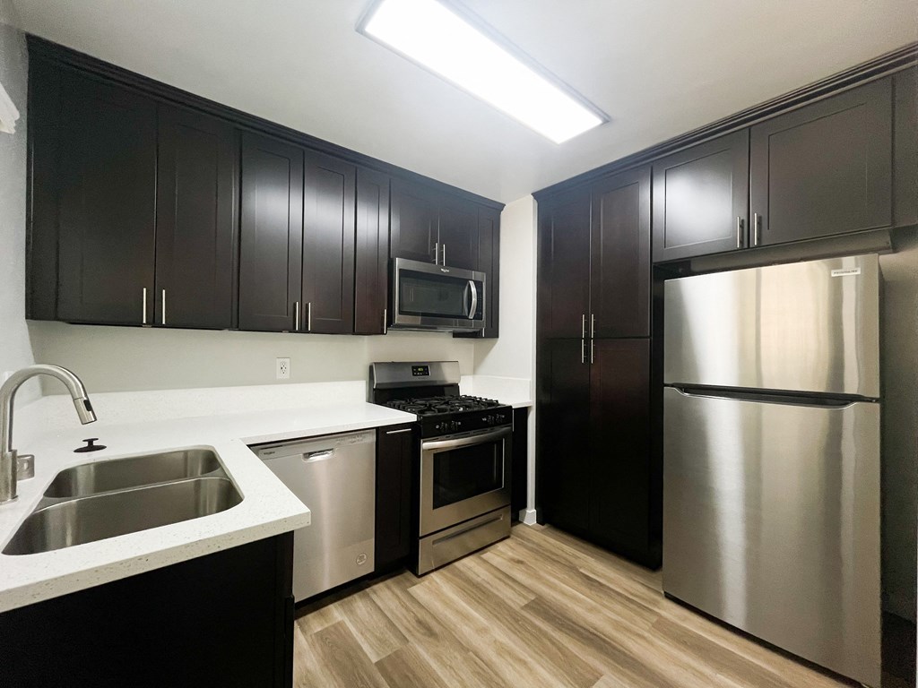 a kitchen with stainless steel appliances and black and white cabinets