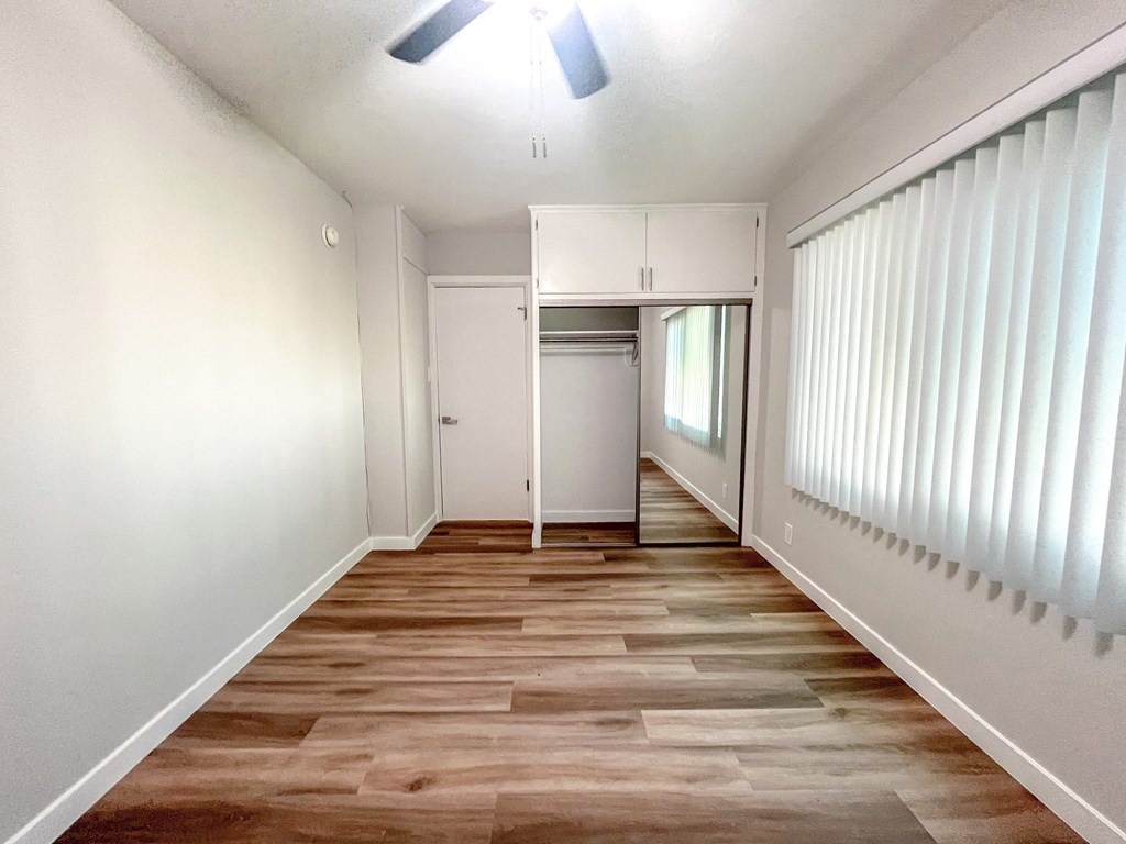 an empty living room with white walls and wood floors