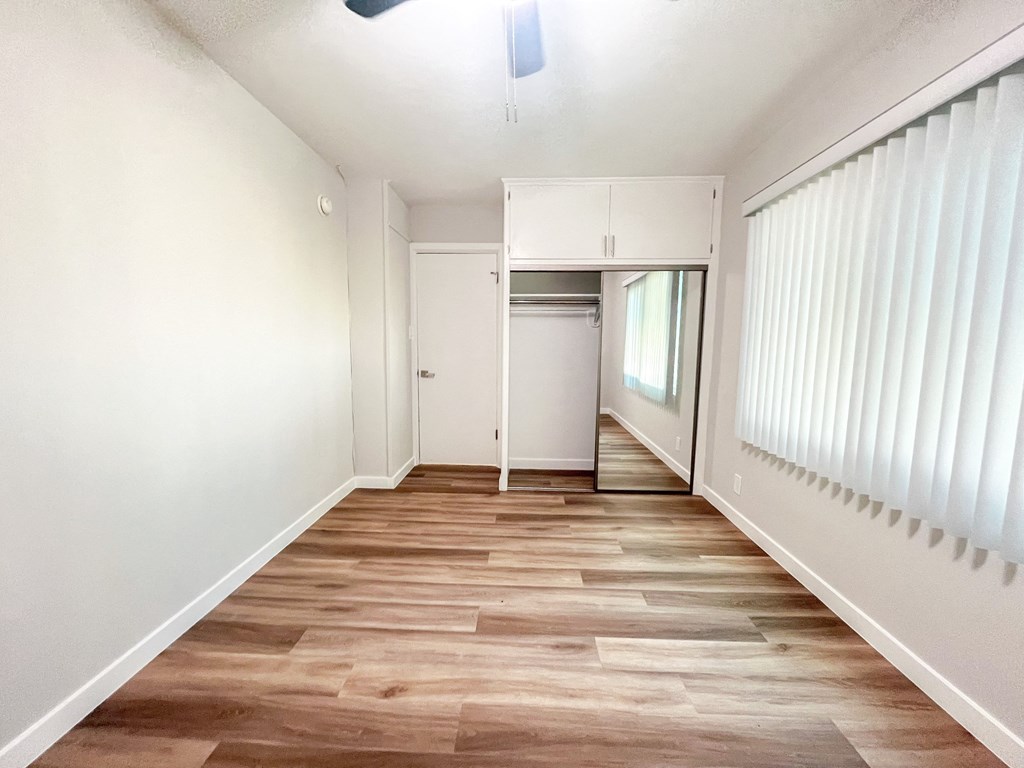 an empty hallway with white walls and wood floors
