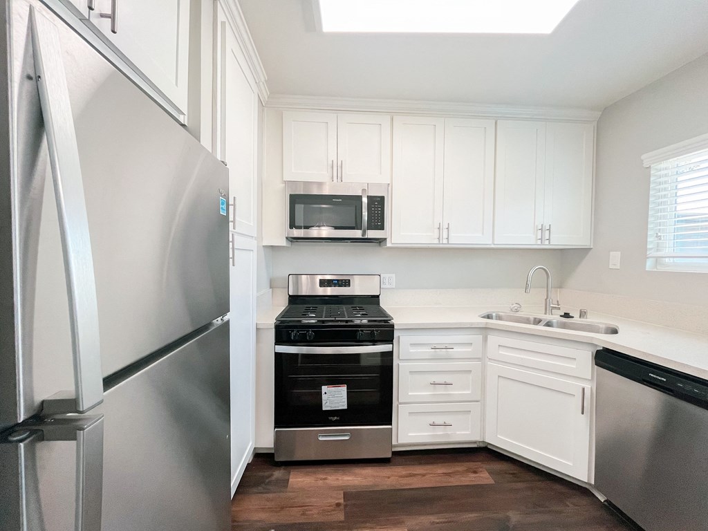 a small kitchen with white cabinets and stainless steel appliances