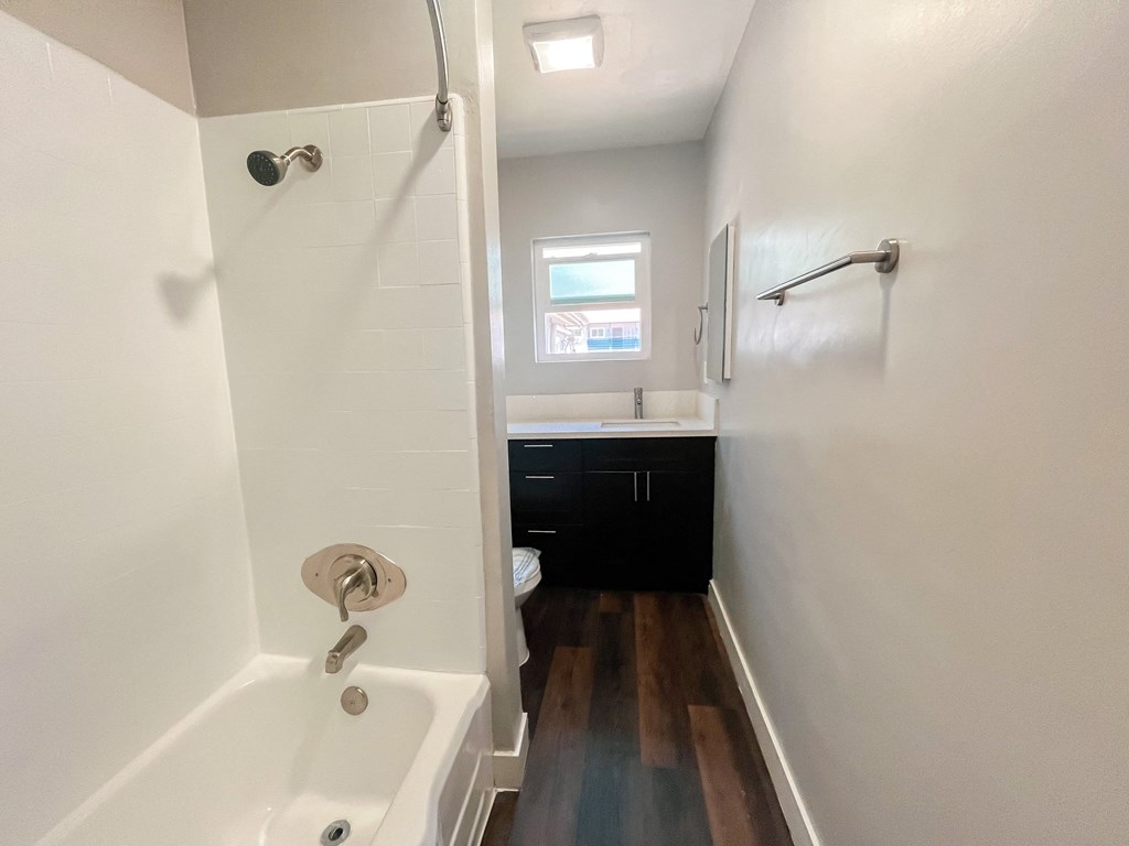 a bathroom with a tub and a shower and a sink