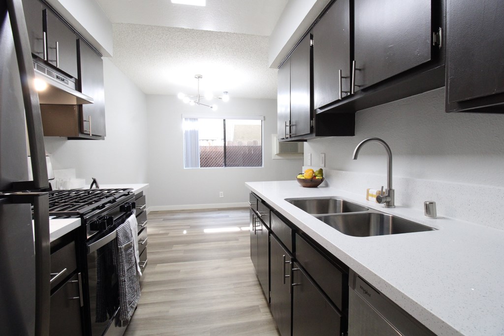 A modern kitchen with black cabinets and stainless steel appliances.