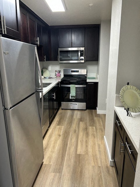 a kitchen with stainless steel appliances and black cabinets